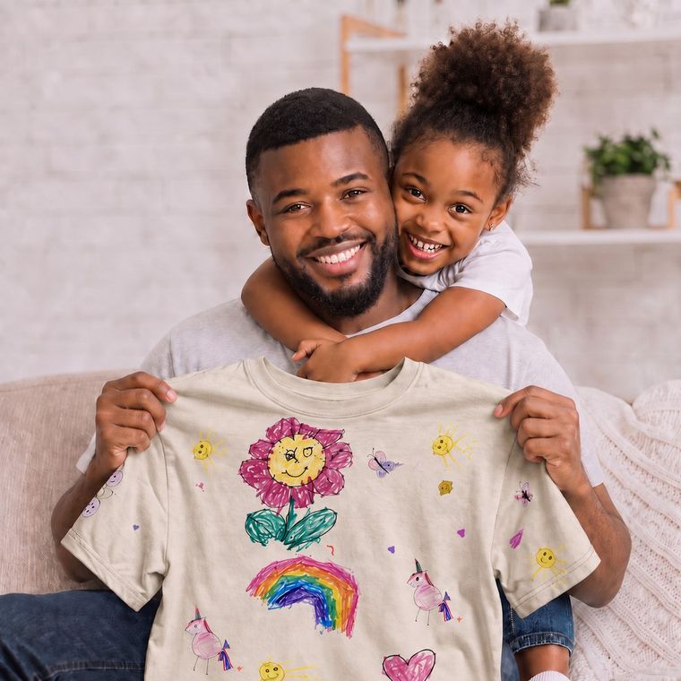Dad holding the tee made from Sara's drawing, Sara hugging him